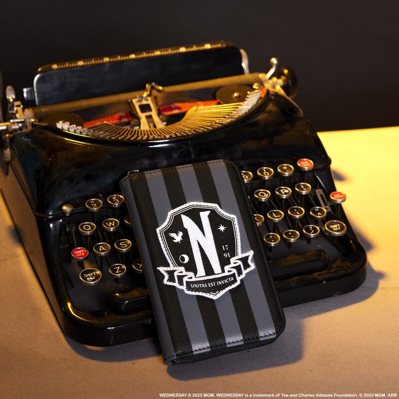 Image of the Nevermore Cosplay Zip Around Wallet leaning against an old typewriter on a desk